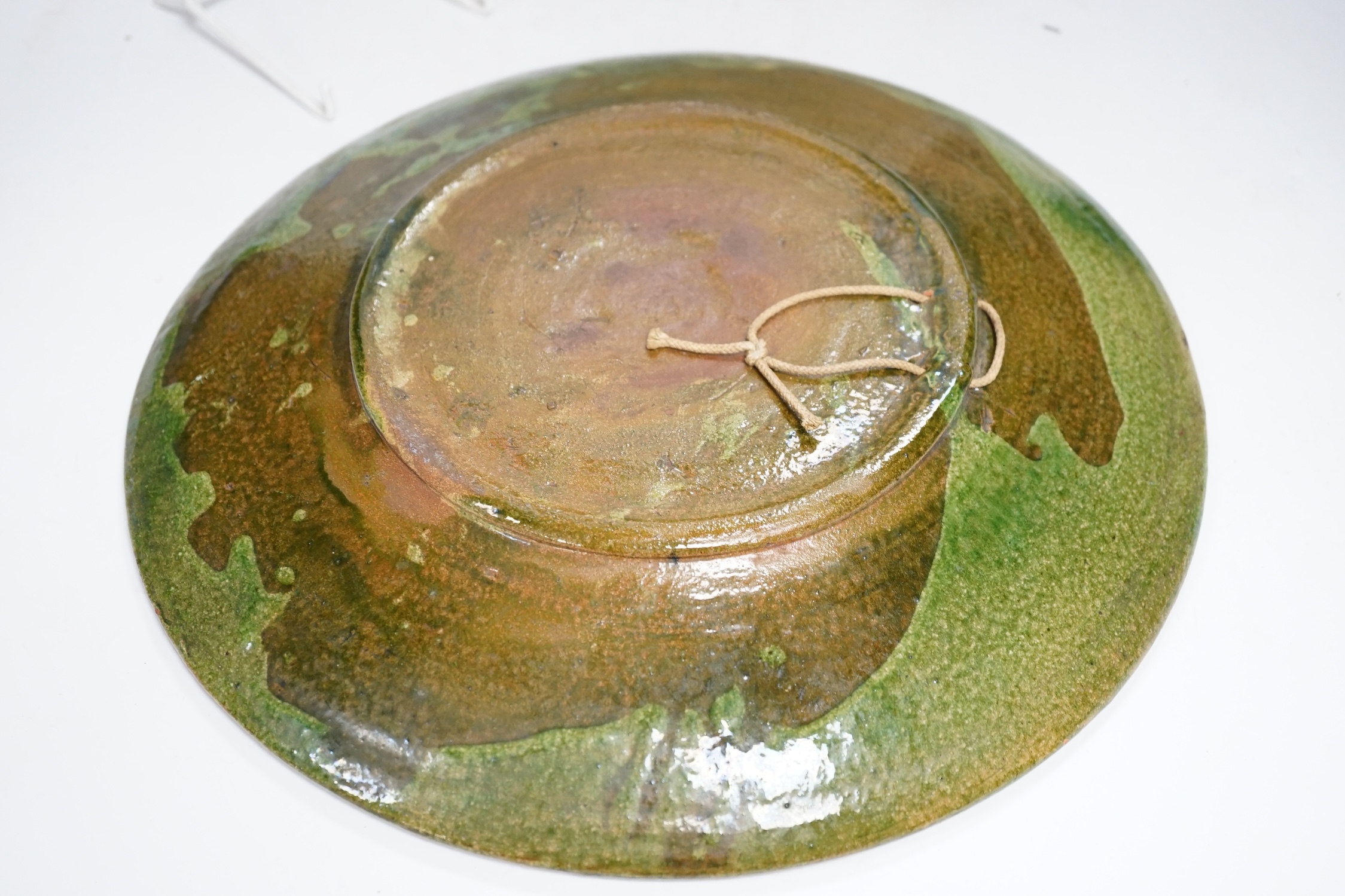 An Arts and Crafts style pewter fish plate with ceramic insets and glass eyes together with a pottery armorial charger, pewter charger 35cm wide